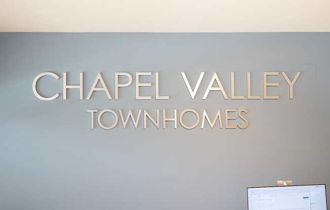 A wall with a sign that says Chapel Valley Townhomes.