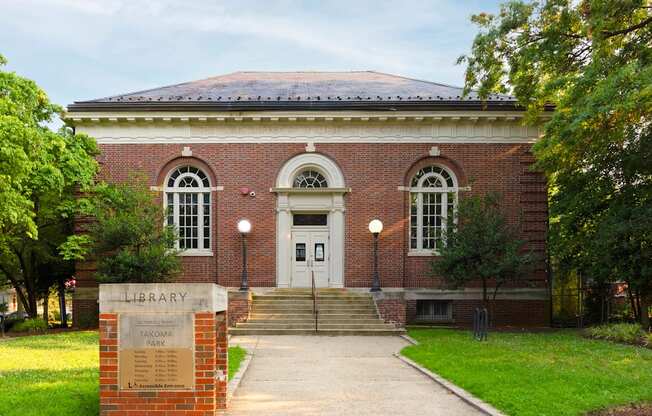 A brick building with a dome roof and a sign that says Library.