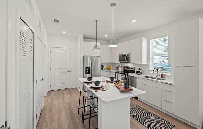 A modern kitchen with white cabinets and a wooden island.