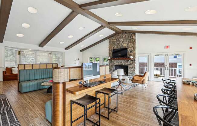 A living room with a stone fireplace and a large window.