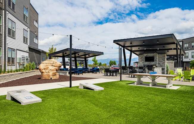 an outdoor patio with picnic tables and a stone fireplace