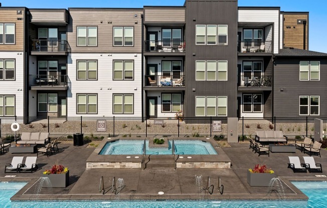 a swimming pool is in front of an apartment building