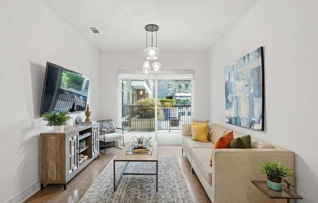 A living and dining room with a couch, and a television at Knox Heights Apartments in Dallas, TX