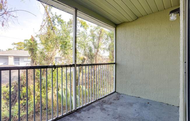 A patio with a metal railing and a view of a residential area.
