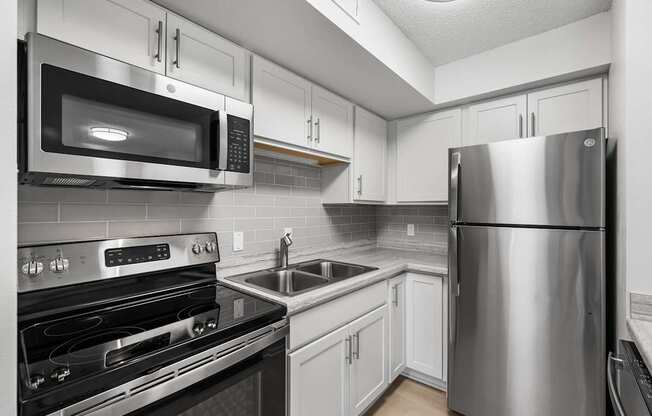 a kitchen with stainless steel appliances and white cabinets