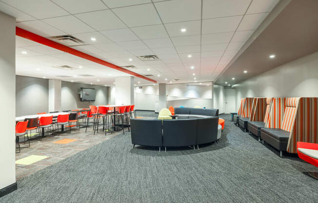 a lounge area in a large room with chairs and couches