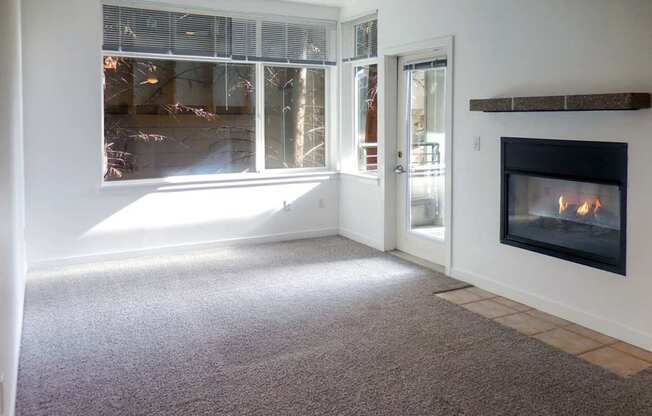 A room with a fireplace and a carpeted floor.