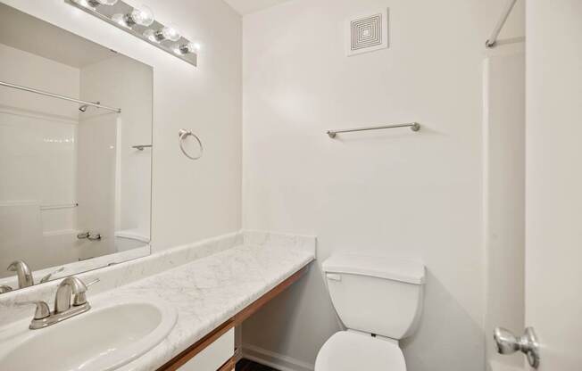 A white toilet sits next to a sink in a bathroom.