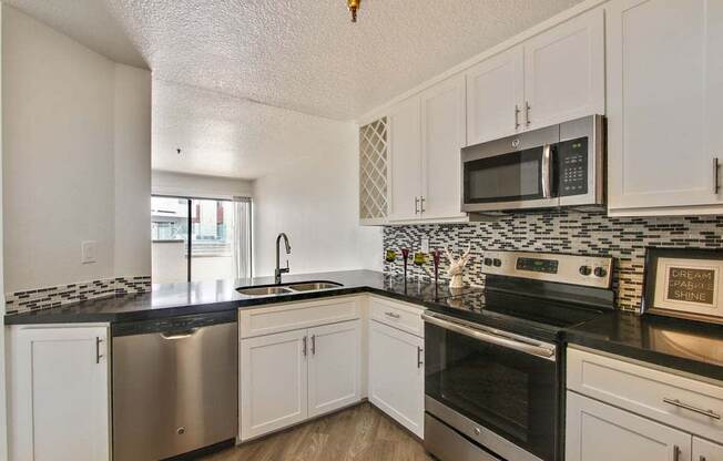 a kitchen with a stove top oven next to a sink  at Masselin Park West, California, 90036