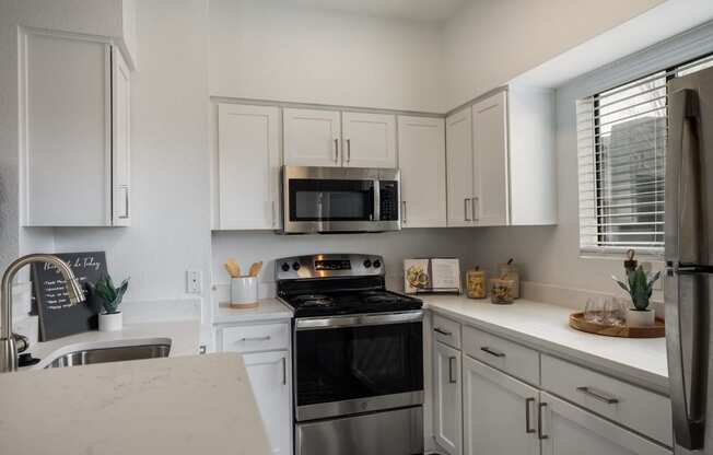 a kitchen with stainless steel appliances and white cabinets