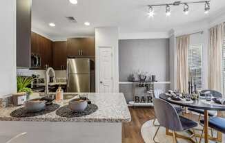 a kitchen and dining area with stainless steel appliances and a granite counter top