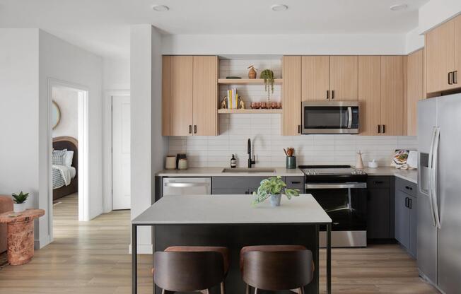 Two-tone cabinetry, open shelving, and a central island create a kitchen designed for gathering and everyday ease.
