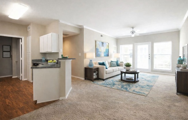 A living room with a white couch and a blue rug.