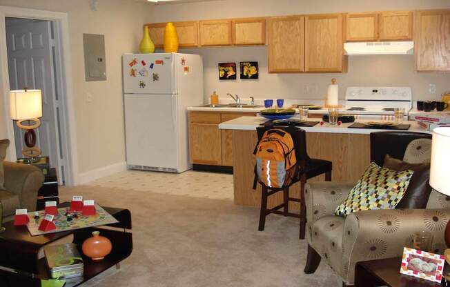 A kitchen with a refrigerator, sink, and stove.