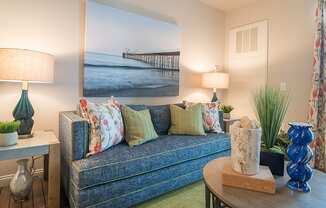 a living room with a couch and a painting on the wall