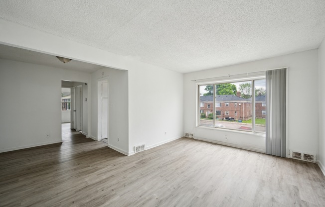 A large empty room with a view of a street outside.