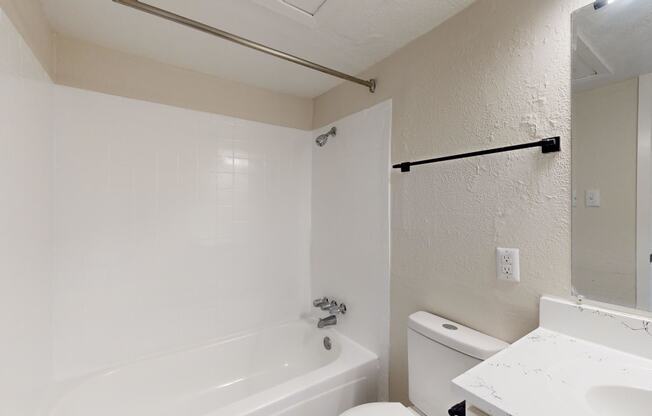 a bathroom with a white toilet and a tub and a sink