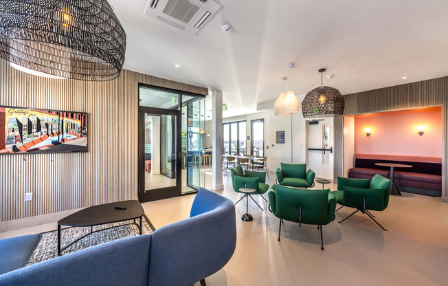 A modern living room with a blue sofa and green chairs.