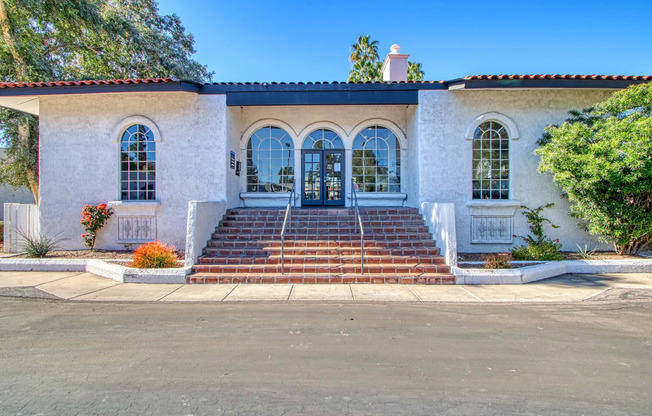 a white building with three doors and three windows