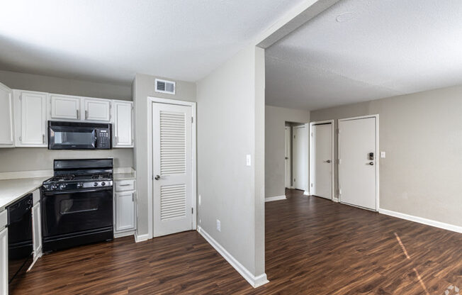 A kitchen with white cabinets and a black stove top oven.