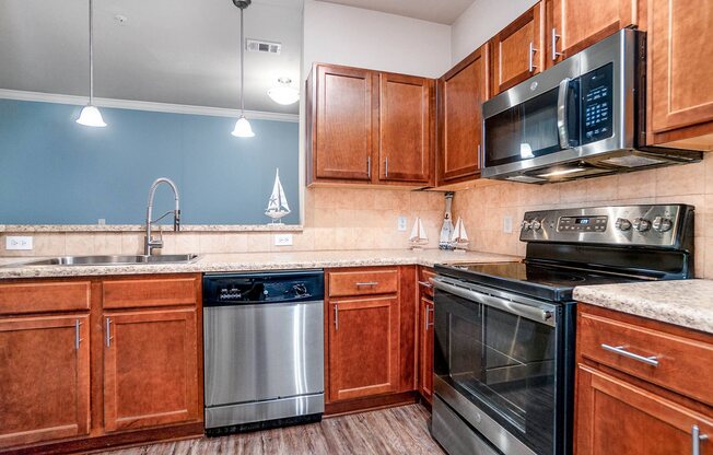 Apartments in Myrtle Beach SC - Lattitude @ The Commons - Spacious Kitchen with Stainless Steel Appliances, Woodstyle Flooring, and Matching Cabinets.