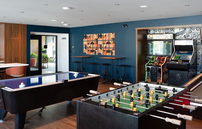 a game room with a foosball table and a video game