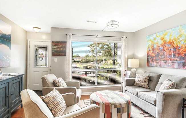 A living room with a grey couch, a chair, and a table.