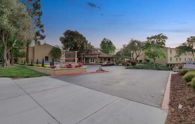 a street with a driveway and houses in the background at Summerwood Apartments, California