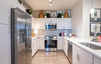 a kitchen with stainless steel appliances and white cabinets