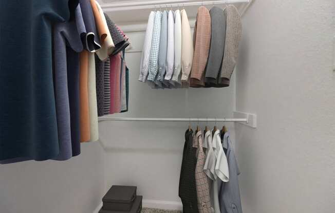 a row of clothes hanging on a rack in a closet