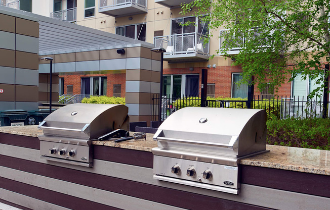 two bbq pits in front of an apartment building