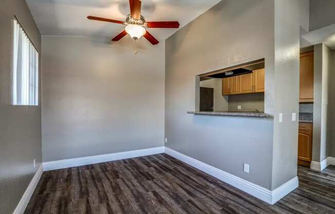 an empty living room with a ceiling fan