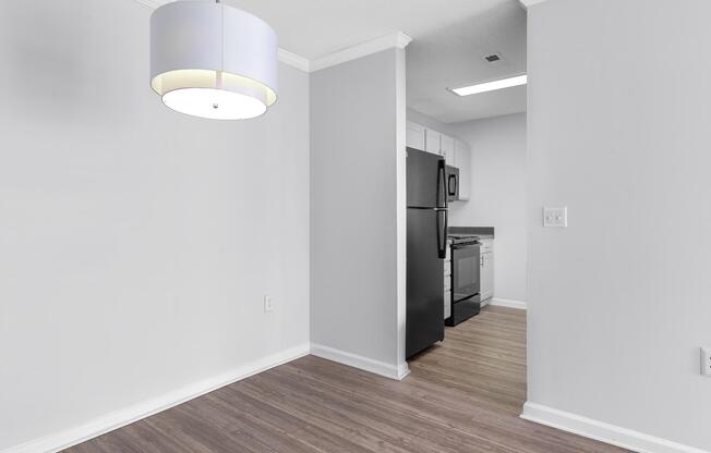 A room with modern lighting and kitchen with black appliances at Ashley Oaks Apartments