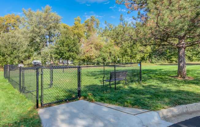 a park with a bench and a chain link fence