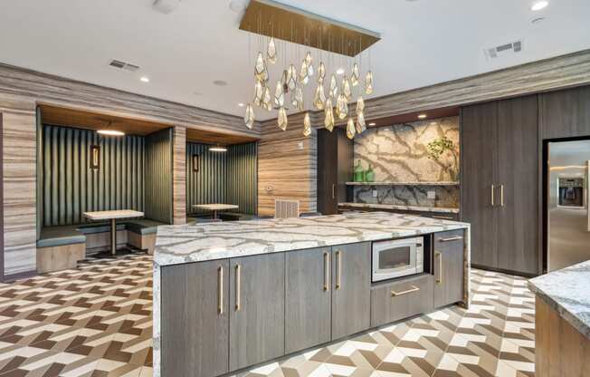 a large kitchen with marble countertops and a chandelier at Link Apartments® Broad Ave, Memphis, TN