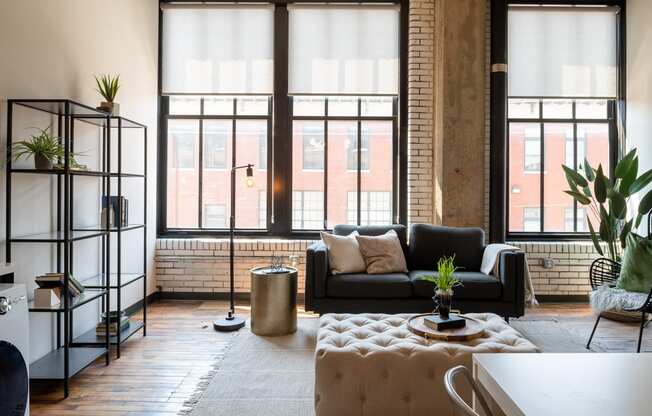 a living area with a couch coffee table and large windows at The Draper, Missouri