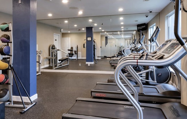 a gym with cardio equipment and weights in a building