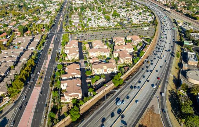 an aerial view of a suburb of a city with highways and cars