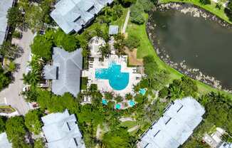 arial view of a swimming pool in the middle of a yard with trees and