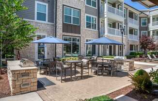 Grilling area with outdoor dining seating  at The Flats at Ballantyne Apartments, North Carolina, 28277