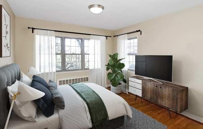 A bedroom with a bed and a tv at Mason Hall in Alexandria, VA 22314