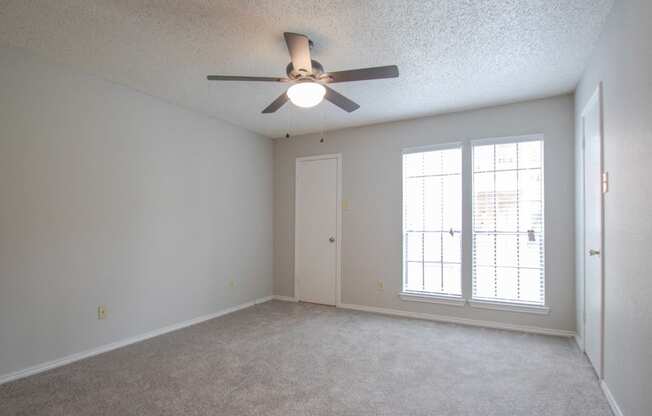 an empty living room with a ceiling fan and a window at The Broadwater at Salado Creek, San Antonio