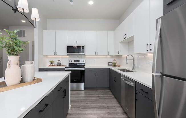A modern kitchen with stainless steel appliances and white cabinets.