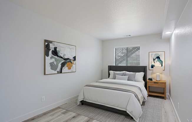 A bedroom with a large bed and a painting on the wall.