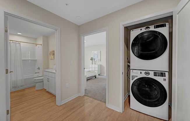 a washer and dryer in a living room with a bathroom and a bedroom