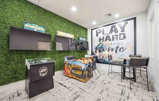 a game room with green turf wall and white brick flooring
