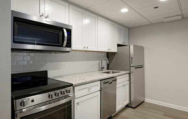 Renovated kitchen with granite countertops and stainless steel appliances at Lenox Club, Arlington