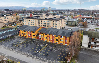 A parking lot in front of a large building with orange and black stripes.