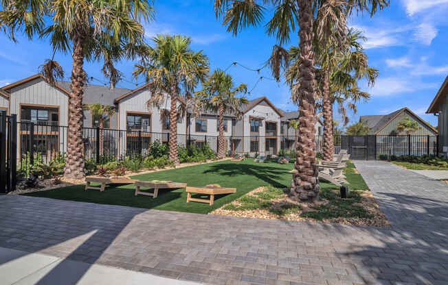 a picnic area with benches and palm trees in front of houses at Canter, Ocala, Florida