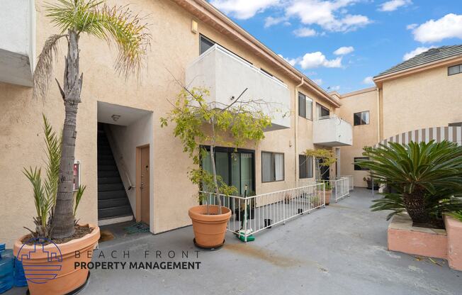 a building with a patio and a palm tree outside of it